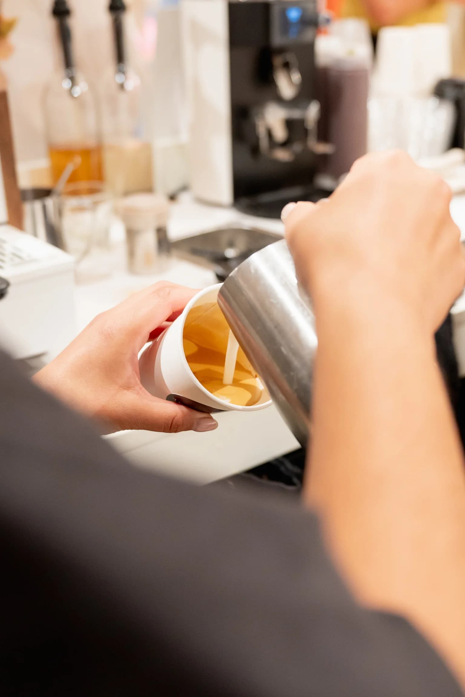 Anechó barista pouring latte art into a cup at a staff appreciation event