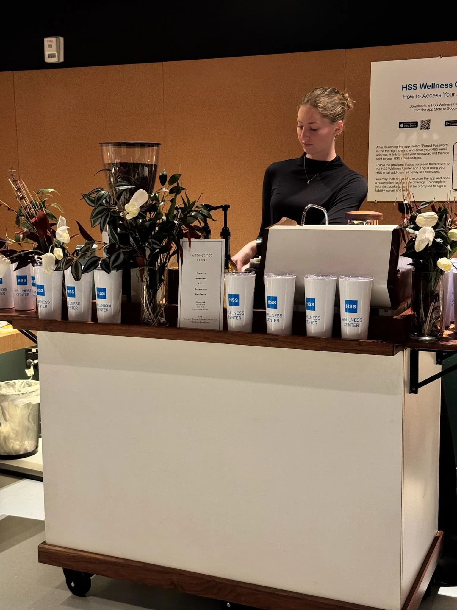 Anechó barista serving espresso from a branded mobile coffee bar at a corporate event